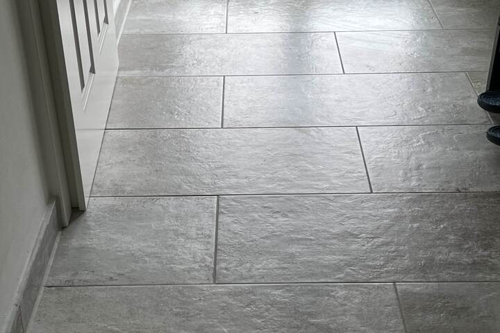 graue Fliesen wurden in einem Flur im Halbversatz verlegt